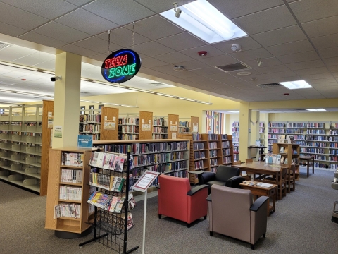 Image of library space with electric sign that reads Teen Zone