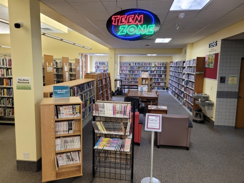 Image of bookstacks with Teen Zone sign