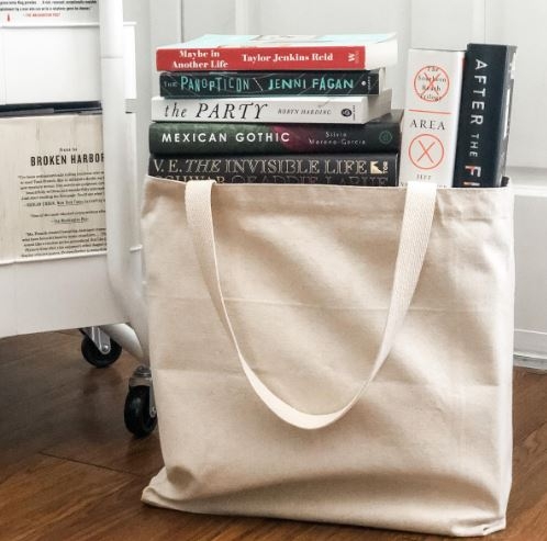 a cream tote bag full of books