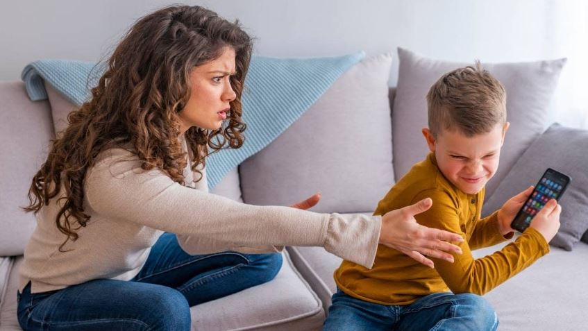 photo of frustrated mom trying to take a phone away from angry kid